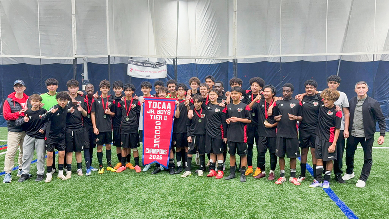 Group photo of Brebeuf team and coaching staff with the TDCAA championship banner