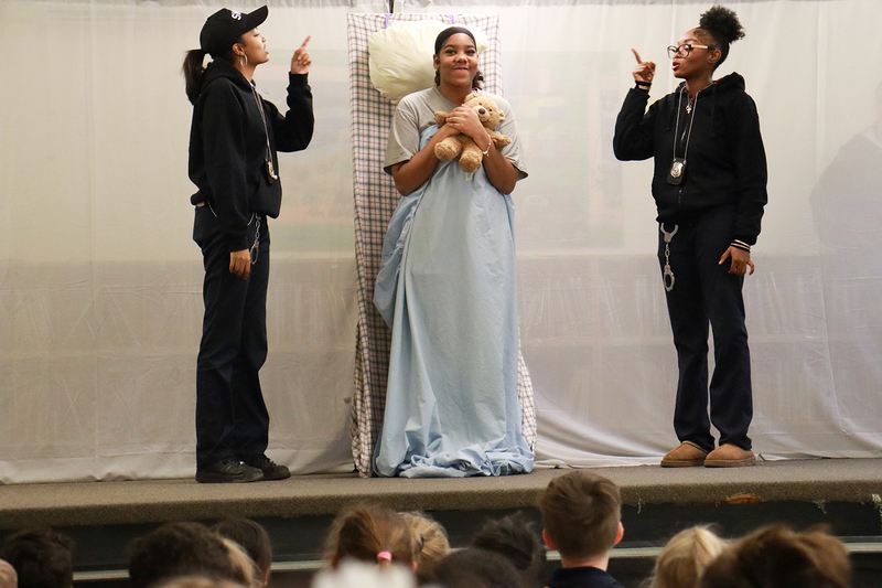 Photo of Notre Dame theatre players acting on stage while St. John students watch from the audience