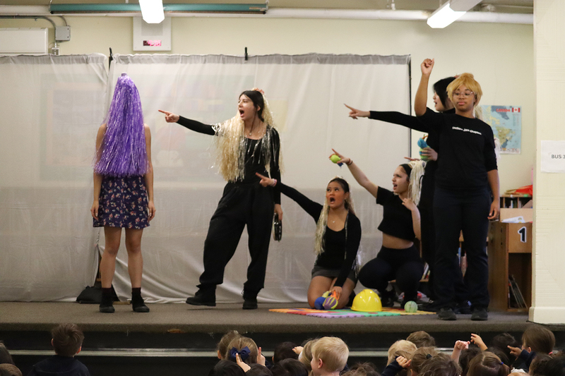 Photo of Notre Dame theatre players acting on stage while St. John students watch from the audience