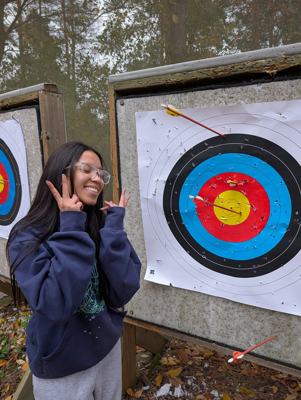 Photo of Loretto College student with an arrow target