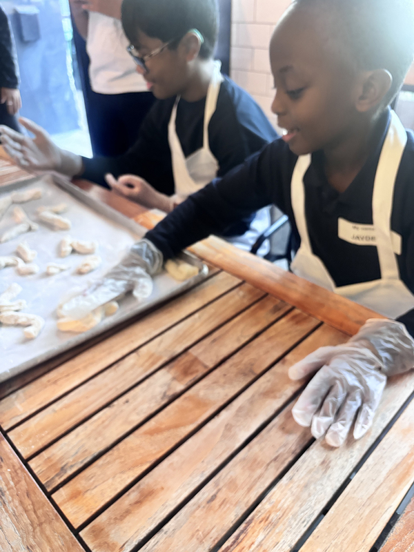 Photo of Santa Maria students and staff making pizza with North of Brooklyn Pizzeria staff