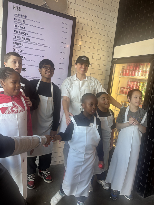 Photo of Santa Maria students and staff making pizza with North of Brooklyn Pizzeria staff
