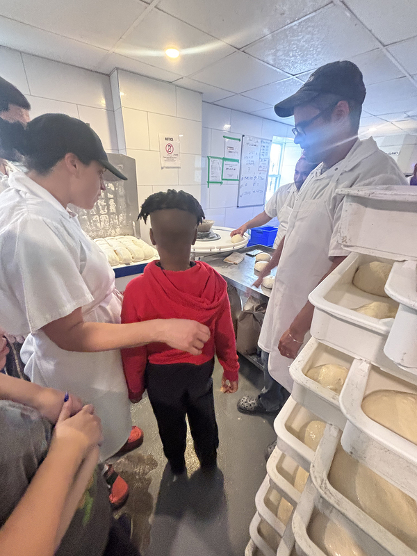 Photo of Santa Maria students and staff making pizza with North of Brooklyn Pizzeria staff