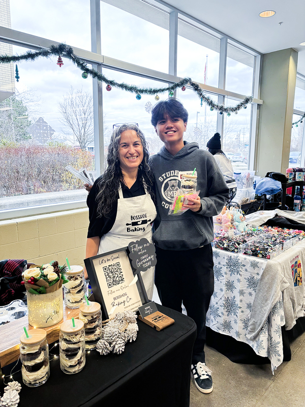 Photo of a stall vendor at the market with a student council member
