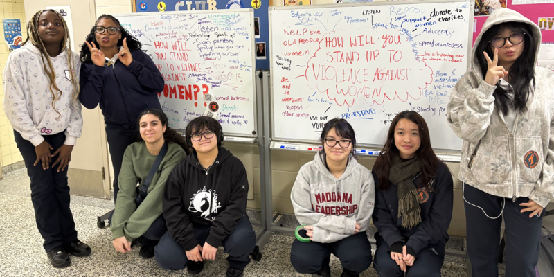 Group photo of Madonna students in front of the displays they created