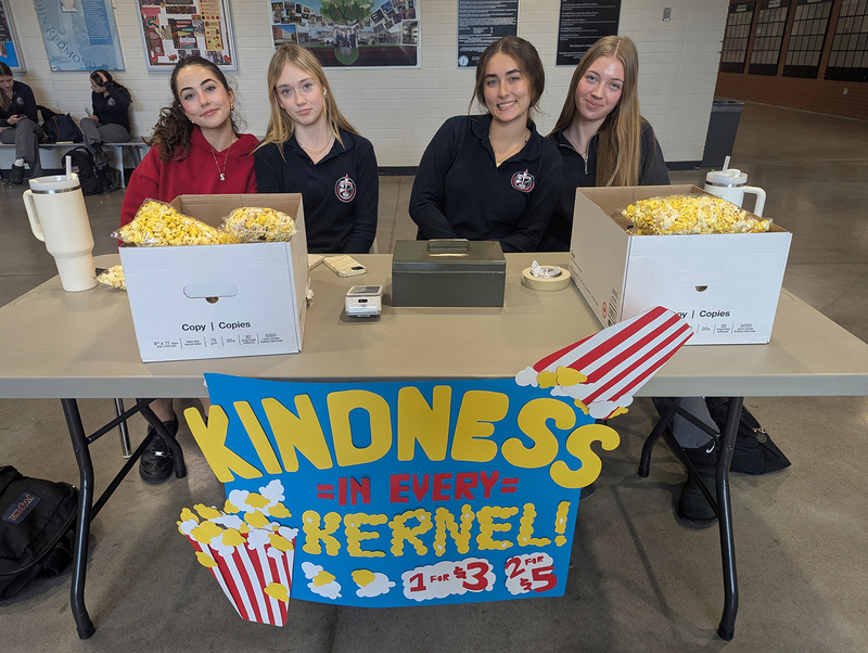 Photo of FJR Key Club students sitting at the popcorn selling table