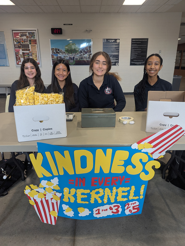 Photo of FJR Key Club students sitting at the popcorn selling table