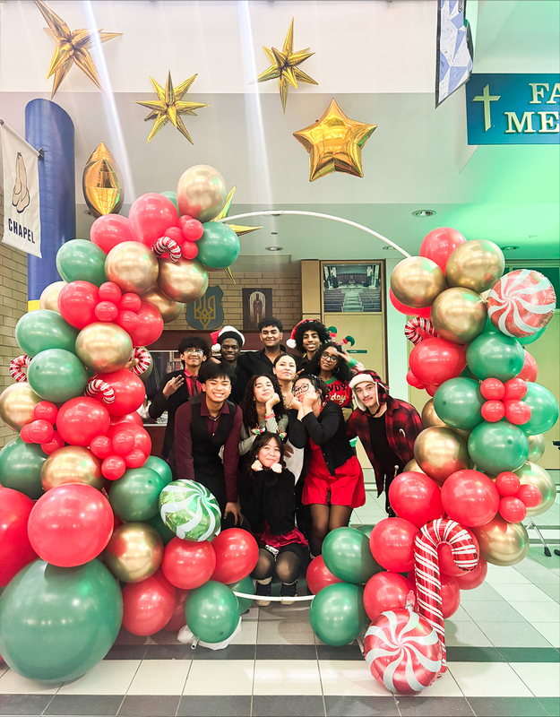 Photo of St. Basil-the-Great students under a Christmas colors themed balloon arch