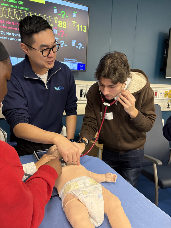 Photo of students using a stethoscope on a dummy baby