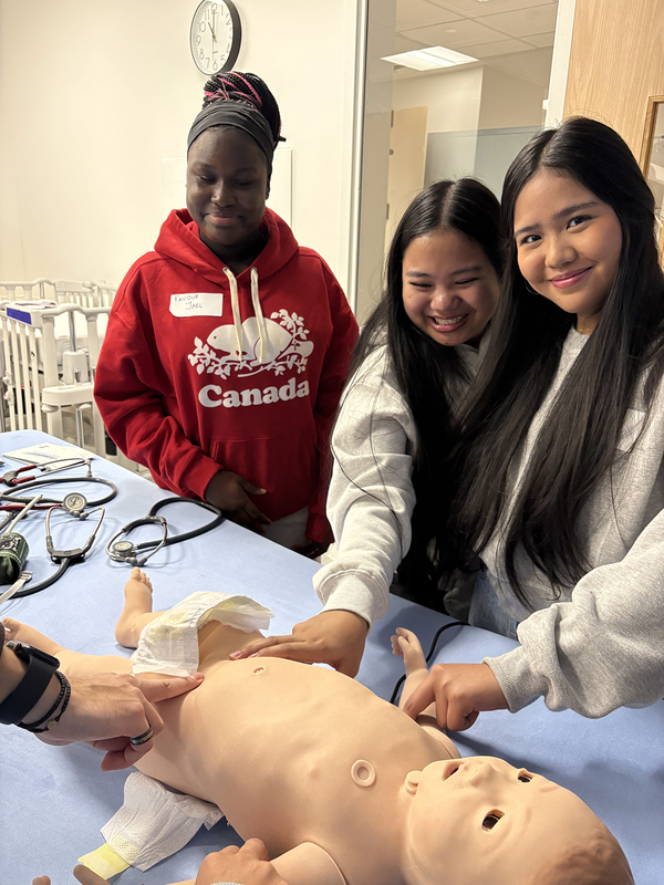 Photo of students studying with a dummy of a baby