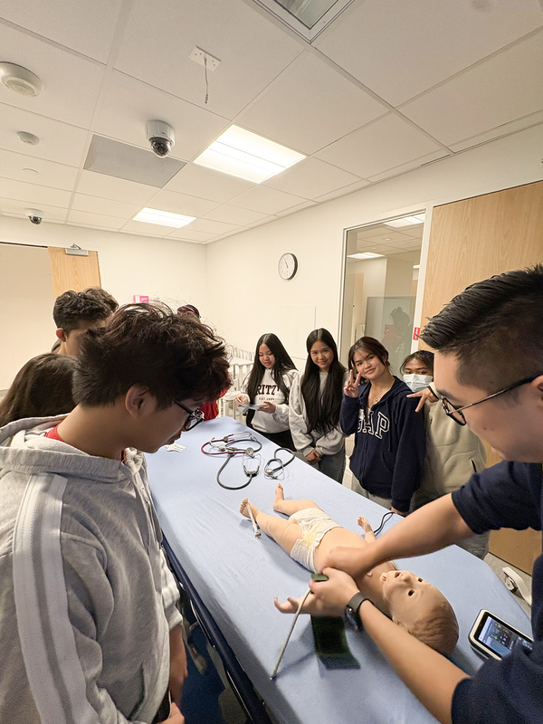 Photo of students studying with a dummy of a baby