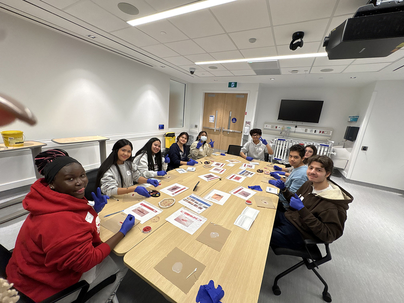 Photo of students and Ms. Esowanne doing an activity together