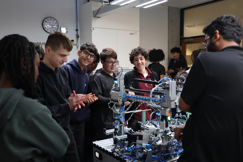 Photo of St. Oscar Romero students watching a robotics rig