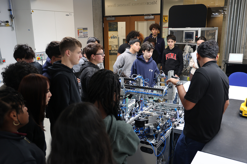 Photo of St. Oscar Romero students watching a robotics rig