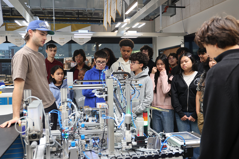 Photo of St. Oscar Romero students watching a robotics rig