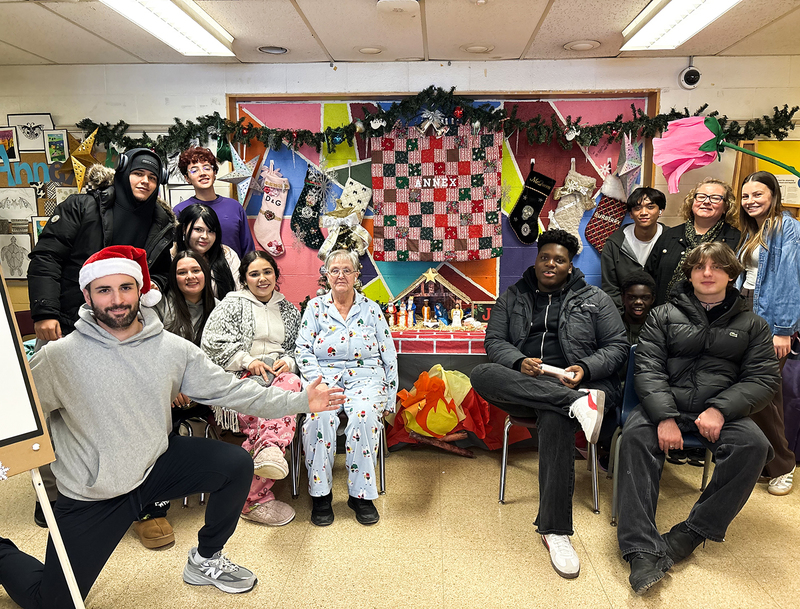 Group photo of Monsignor College Annex students and staff together with the display they built