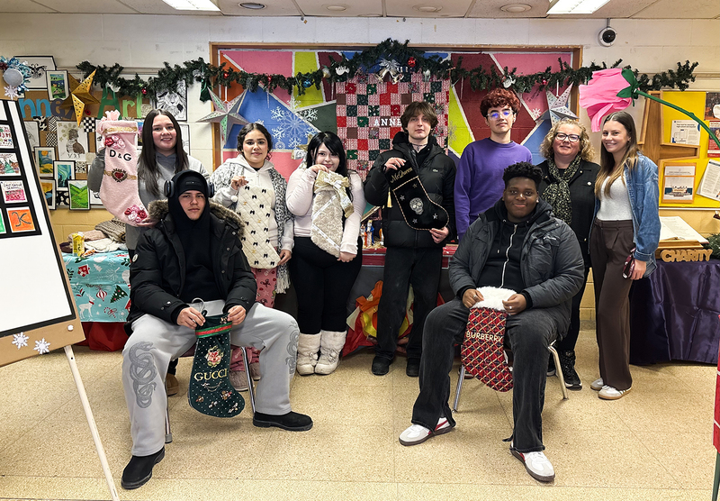 Group photo of Monsignor College Annex students and staff together with the display they built