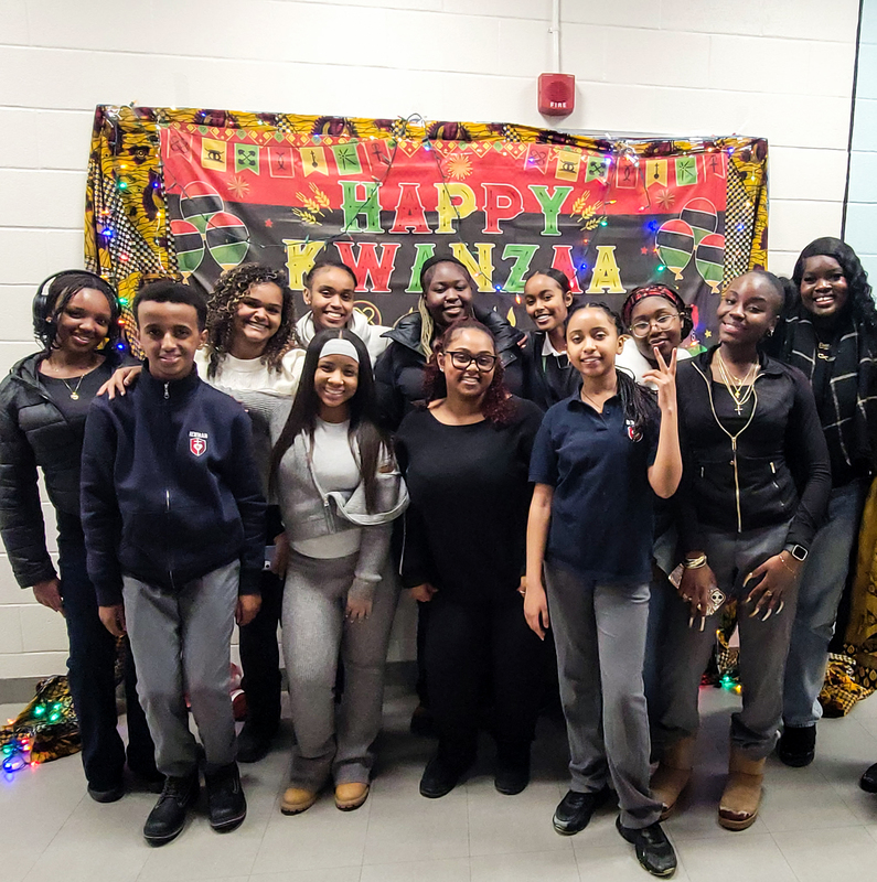 Group photo of students in front of the Kwanzaa banner