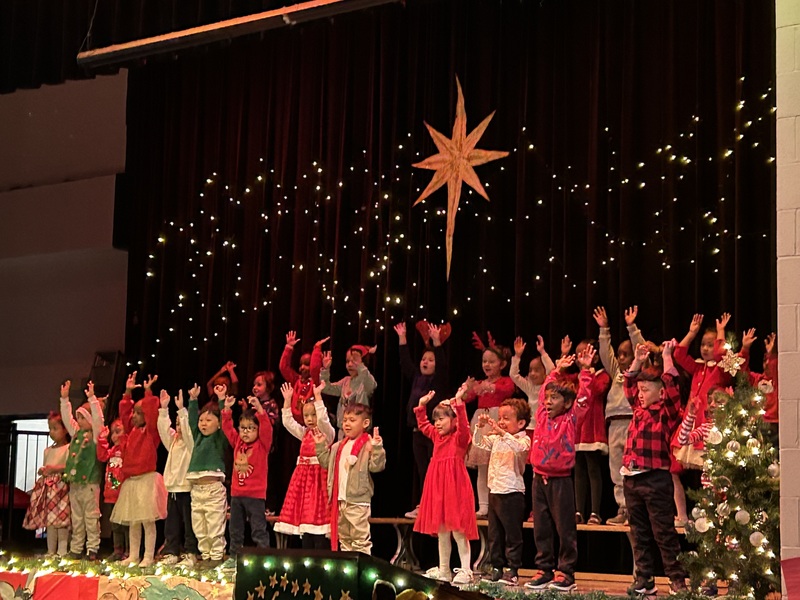 A group of young students performing on a stage for a Christmas play