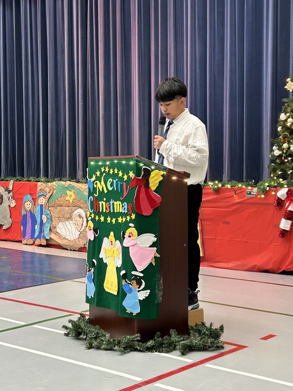 A young student speaking at a podium