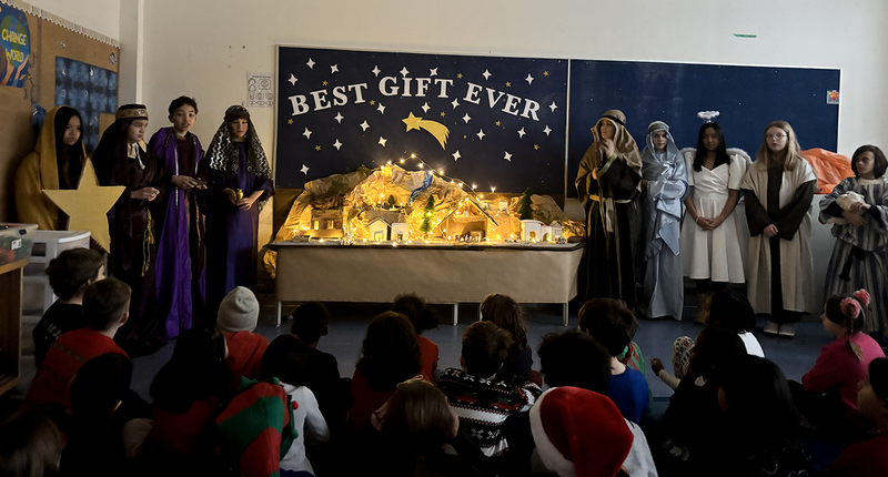Photo of St. Brigid Grade 7 students presenting their Nativity Scenes in costume to the younger grades