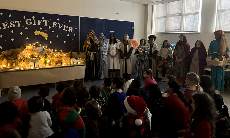 Photo of St. Brigid Grade 7 students presenting their Nativity Scenes in costume to the younger grades
