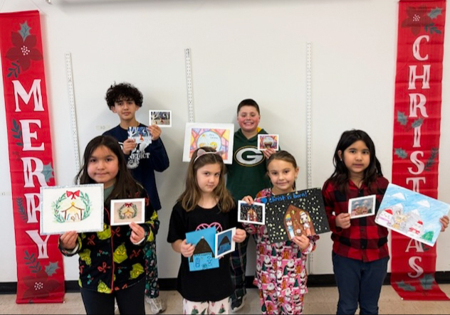 Photo of St. Benedict students holding up the Christmas cards they designed