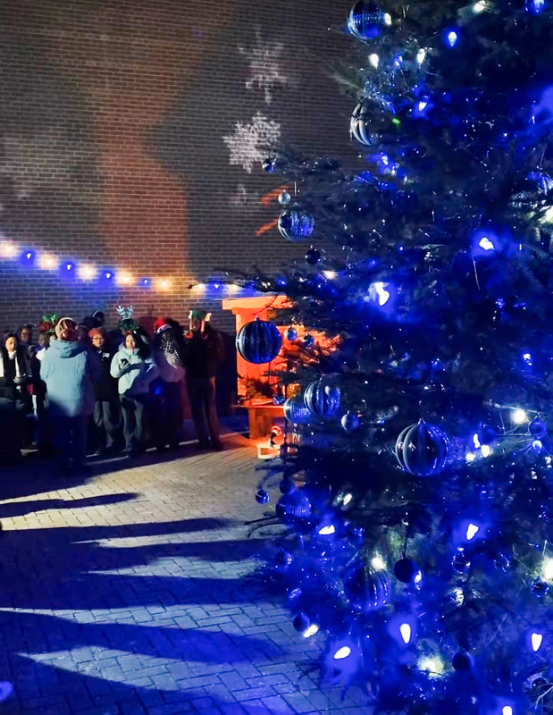 Photo of students gathered around the Christmas tree