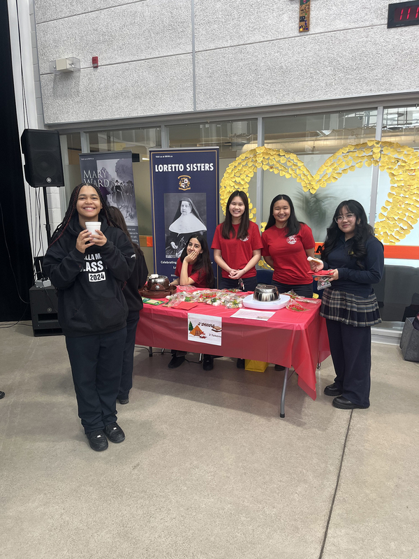 Photo of Loretto College students in charge of a s'mores table
