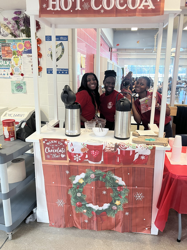 Photo of Loretto College students in charge of a hot drinks booth