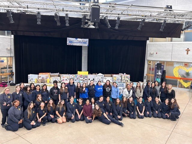 Group photo of Loretto College students with their project boards behind them