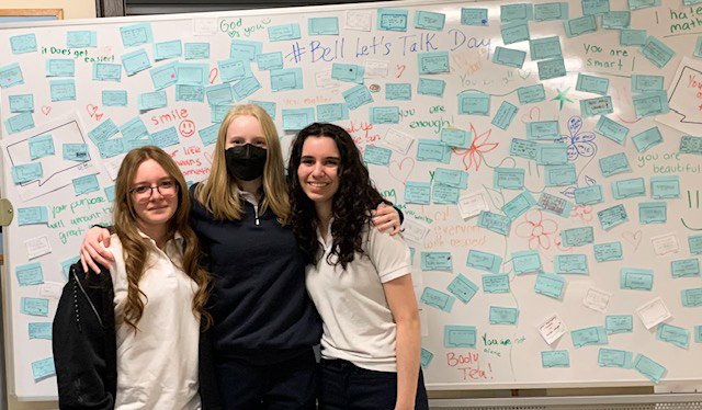 Photo of Loretto Abbey students posing together with the positive messages on the board behind them