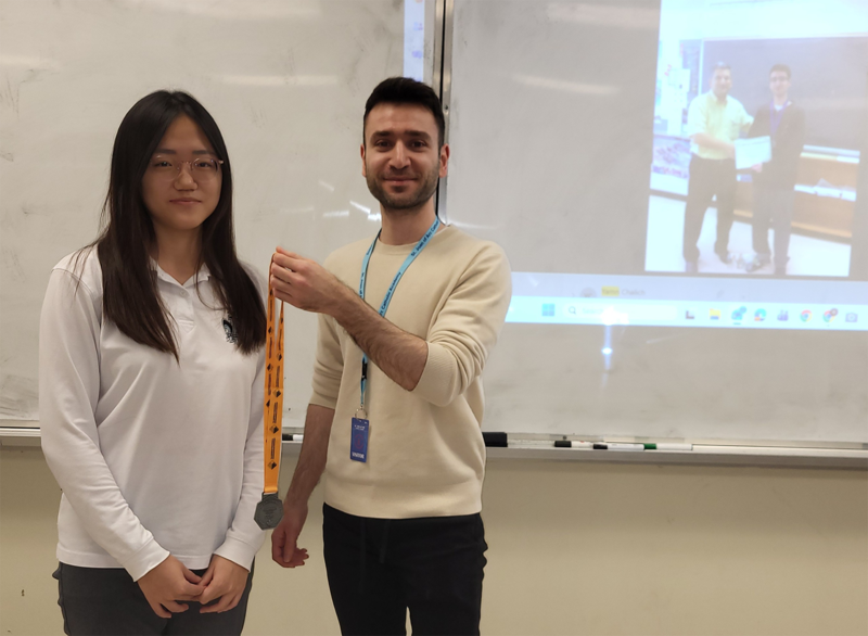 Photo of Suyeon wearing her medal, along with Yamn 