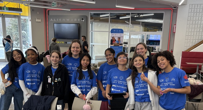 A group of girls in blue shirts that say "girls who game"