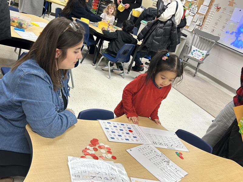 Adults and children participating in an activity in a classroom.