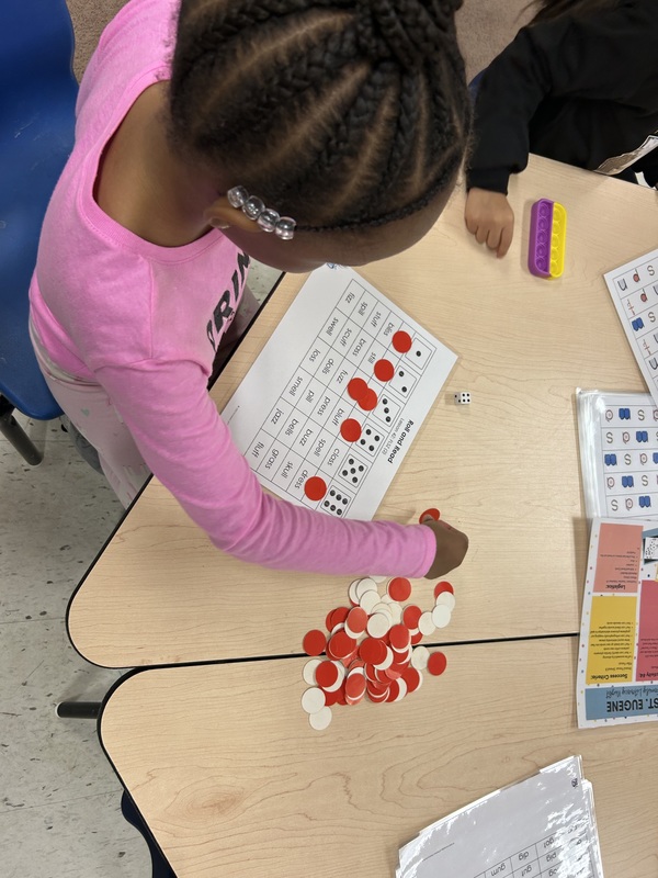 Adults and children participating in an activity in a classroom.
