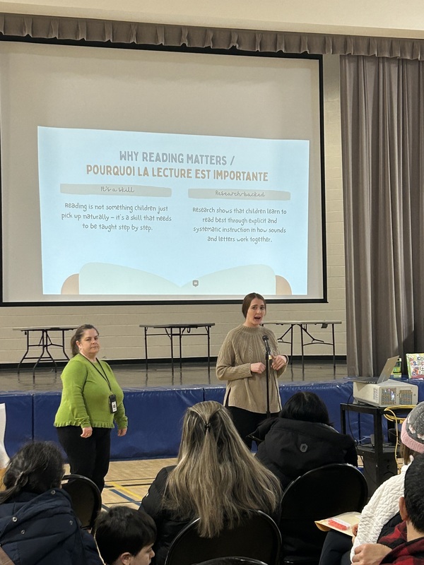 Adults giving a presentation in a gym.