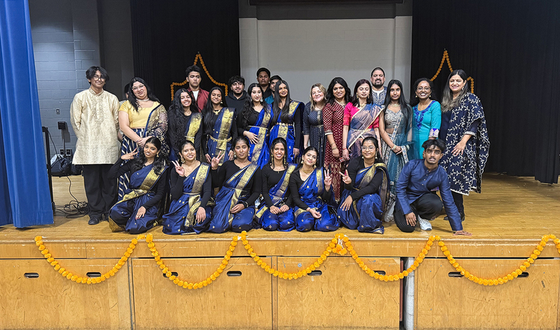 Group photo of performing students and adults in cultural clothing