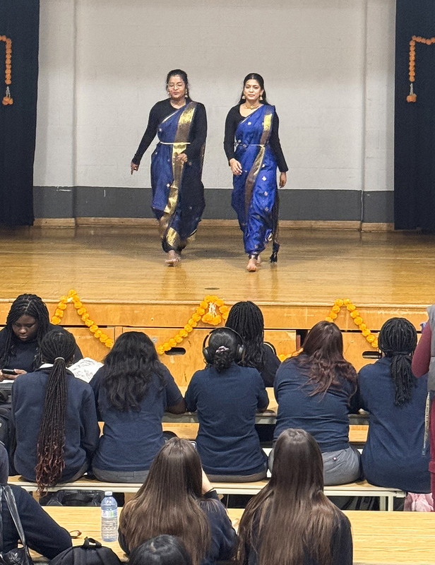 Photo of students in cultural clothing performing on stage