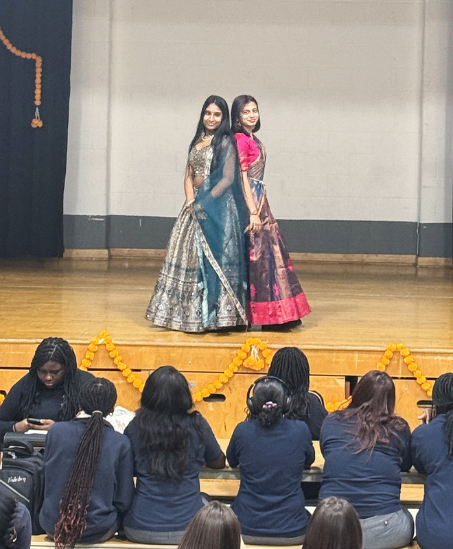 Photo of students in cultural clothing performing on stage