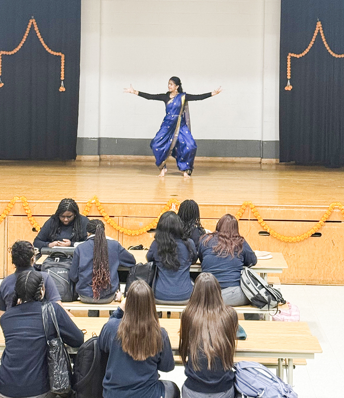 Photo of students in cultural clothing performing on stage