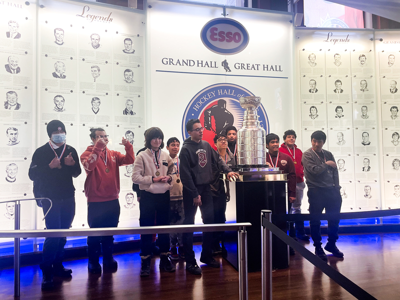Photo of St. Oscar Romero ISP students and staff posing with the Stanley Cup in the Hockey Hall of Fame