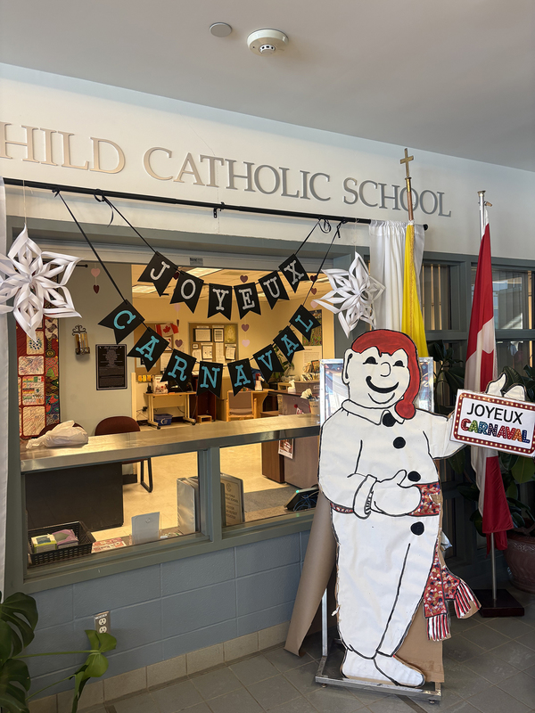 Photo of Bon Homme the snowman in front of the Holy Child Catholic School entrance