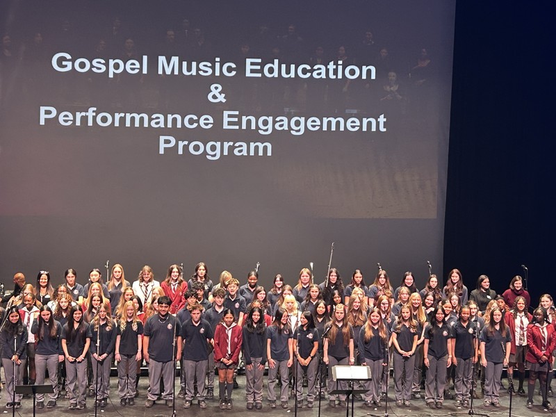 A large group of students performing music on a stage.