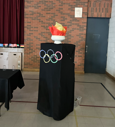 Photos of the podium decorated with the Olympics logo at the St. Angela Multicultural Day and festive ceremony
