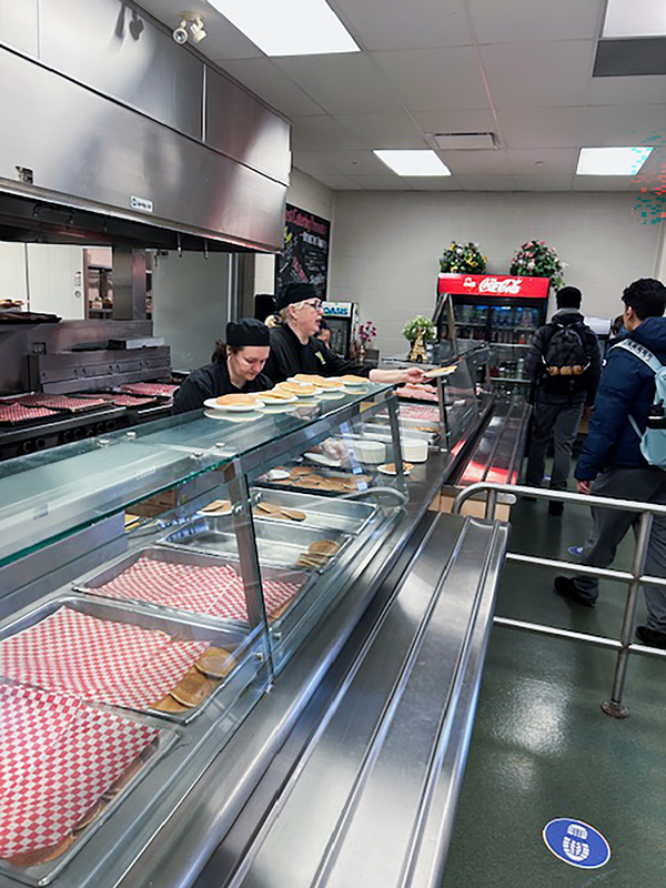 Photo of Redmond students being served pancakes by the staff