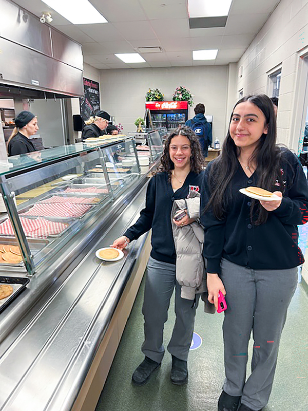 Photo of Redmond students being served pancakes by the staff