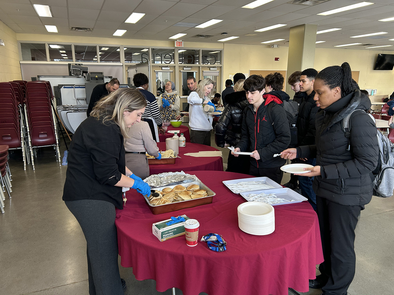 Photo of MPJ community members serving and getting breakfast