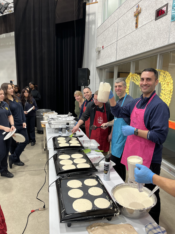 Photo of LCS Kings making and serving pancakes to students
