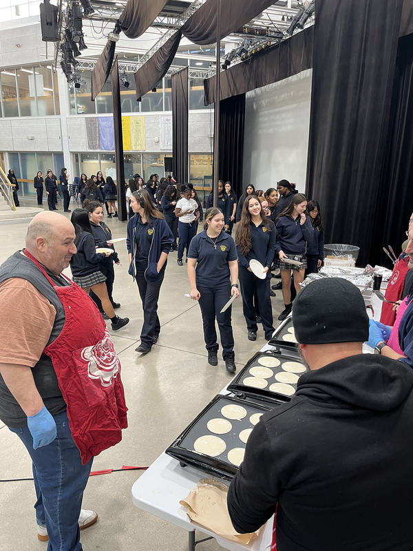 Photo of LCS Kings making and serving pancakes to students